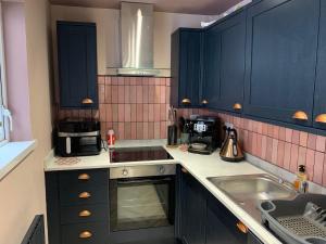 ベルファストにある3 bedroom house- East Belfastの青いキャビネットとシンクのあるキッチン