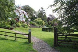 a wooden fence in front of a house at Knapp House Lodges in East Anstey