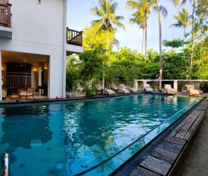 a swimming pool in a villa with palm trees at Aura By Epic Collection in Mirissa