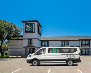 a white van parked in front of a building at Quality Inn & Suites Irving DFW Airport South in Irving