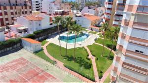 an aerial view of a building with a pool and palm trees at Terrasol Estudios Plazamar in Torre del Mar