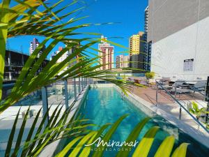 a swimming pool in a city with tall buildings at Simple Smart Residence in Tambaú