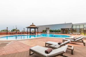 a pool with a gazebo next to a building at Hotel de Convenções de Talatona, HCTA in Luanda