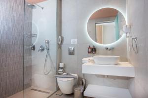 a bathroom with a toilet and a sink and a shower at Mastichari Bay Hotel in Mastihari