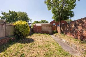 a yard with a brick wall and a fence at Peaceful Room in Doncaster Shared House w Kitchen in Doncaster