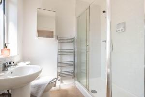 a white bathroom with a sink and a shower at Peaceful Room in Doncaster Shared House w Kitchen in Doncaster