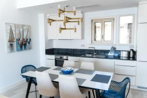 a kitchen with a dining room table and chairs at Three Bedroom Family Apartment - Lustica Marina Village in Radovići