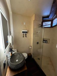 a bathroom with a toilet and a glass shower at Hotel Boutique KaraKara in El Cuyo