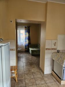a kitchen with a room with a couch and a table at A cozy little house in Joniškis