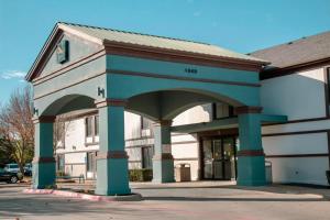 a blue and white building with an archway at Quality Inn & Suites Irving DFW Airport South in Irving