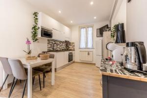 a kitchen with a table and a counter top at Trilocale vicino Metro B con Self Check In e Wi-Fi in Rome