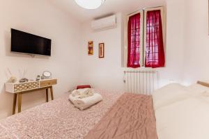 a bedroom with a bed with a tv on the wall at Trilocale vicino Metro B con Self Check In e Wi-Fi in Rome