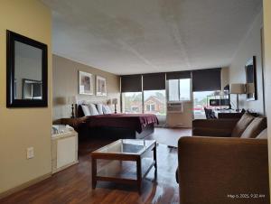 a living room with a couch and a table at Allen Park Motor Lodge in Allen Park