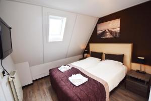 Een bed of bedden in een kamer bij Hotel Noordzee