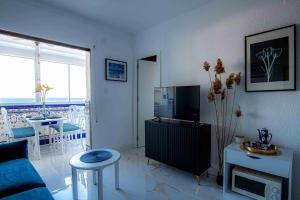 a living room with a blue couch and a tv at Sea View La Mata Apartment in La Mata