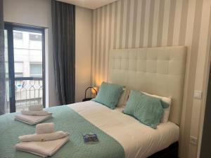 a bedroom with a bed with blue pillows and a window at OPORTO APARTMENT LUXURY in Porto