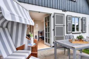 a patio with a table and chairs and a house at Ferienhaus Küstenkind Feriendorf 08 Klein Stresow Rügen by ruyastay in Putbus