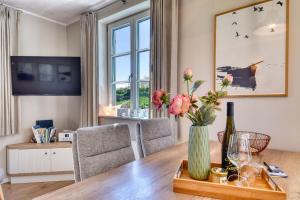 a living room with a wooden table with a vase of flowers at Ferienhaus Küstenkind Feriendorf 08 Klein Stresow Rügen by ruyastay in Putbus