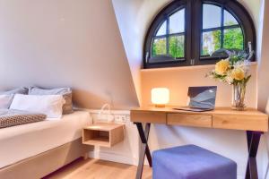 a bedroom with a bed and a desk with a window at Ferienhaus Küstenkind Feriendorf 08 Klein Stresow Rügen by ruyastay in Putbus