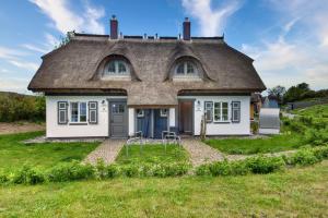 a small house with a thatched roof at Ferienhaus Küstenkind Feriendorf 08 Klein Stresow Rügen by ruyastay in Putbus