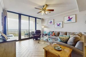 a living room with a couch and a ceiling fan at Island Gem 710 in Dauphin Island