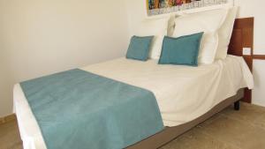 un letto con due cuscini blu sopra di Ocean Roof a Santa Maria