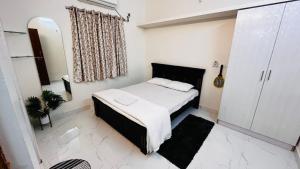 a small bedroom with a bed and a mirror at Boutique Bungalow 458 in Secunderabad
