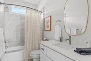Un baño con lavabo, inodoro y espejo. en Casa Verde, en Durham 59 fotos más