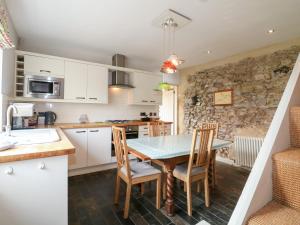 a kitchen and dining room with a table and chairs at Jasmine Cottage in Bakewell