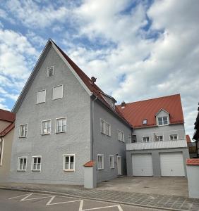 Un gran edificio gris con dos puertas de garaje blancas. en Trendy Appartement im Zentrum von Nördlingen 50 qm, en Nördlingen