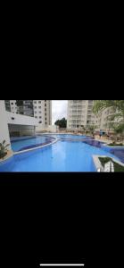 a large blue swimming pool with buildings in the background at Bastos e Silva in Caldas Novas +9 photos