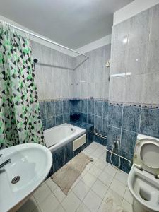 a bathroom with a sink and a toilet and a tub at Luxe & Sérénité suites in Bin Rhilouf