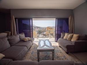 ミンデロにあるApartamentos Octane Mindeloのリビングルーム(窓の前にソファとテーブル付)