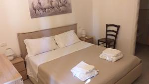a bedroom with a bed with two towels on it at casa nonno luigi in Montalbano