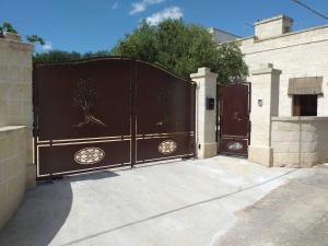 a pair of gates with trees on them in a driveway at casa nonno luigi in Montalbano