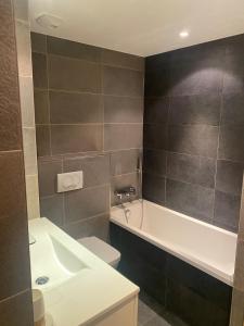 Un baño con lavabo, inodoro y bañera. en "Le CLOS DE L'YRET" Appartement avec grande terrasse en face des pistes, en Le Monêtier-les-Bains