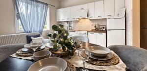 a dining room table with plates and glasses on it at Kaloudis Studios & Apartments in Dassia