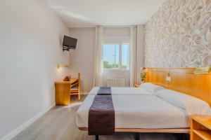 ein Schlafzimmer mit großem Bett und Fenster in der Unterkunft Hotel Rey Arturo Burgos in Villagonzalo-Pedernales