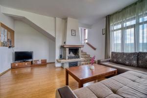 a living room with a couch and a fireplace at Guest House Ivanini Houses in Tryavna