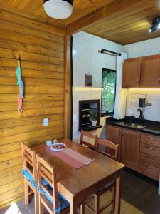 una cucina e una sala da pranzo con tavolo e sedie in legno di Cabanas LUPE Pedro a Governador Celso Ramos