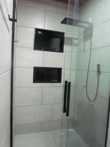 bagno con doccia e TV a parete di Cabanas LUPE Pedro a Governador Celso Ramos Altre 23 foto