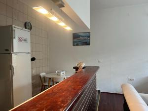 a kitchen with a counter and a refrigerator and a table at La Bocca Apartment - Airport, Parking, AC, Bidet, Coffee Machine, PS3 in Sarajevo +25 photos