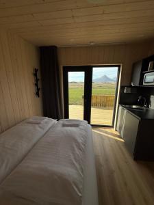 a bedroom with a bed and a sliding glass door at Sefdalur in Höfn