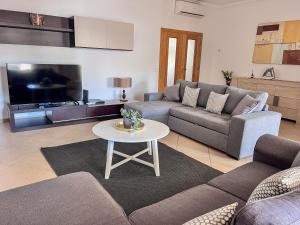 a living room with a couch and a table at Silver Globe in Albufeira