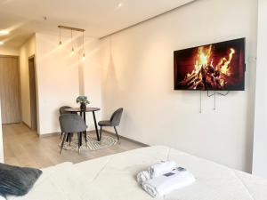 キトにあるLuxury Suite Acqualina Quitoのベッド1台、テーブル(壁にテレビ付)が備わる客室です。