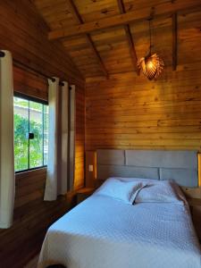 una camera da letto con un letto in una stanza di legno di Cabanas LUPE Pedro a Governador Celso Ramos