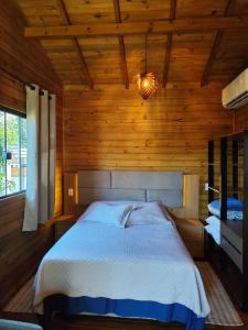 una camera da letto con un letto in una stanza di legno di Cabanas LUPE Pedro a Governador Celso Ramos