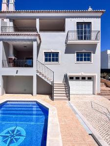 a villa with a swimming pool in front of a house at Silver Globe in Albufeira