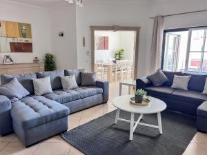 a living room with blue couches and a table at Silver Globe in Albufeira