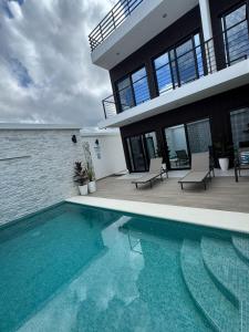 a house with a swimming pool in front of a house at Ocean Dream Apartment E2-A4 in San Juan del Sur